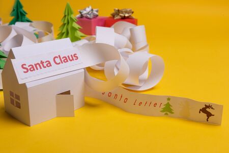 Long twisted expanded letter for Santa Claus. Copy space. yellow background. Santa Claus paper home at north pole.の写真素材