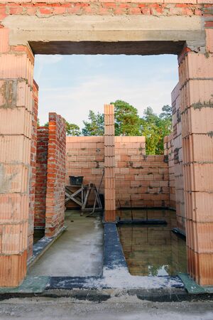 Interior of a Unfinished Red Brick House Walls under Construction without Roofing.の写真素材