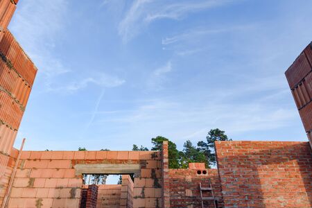 Interior of a Unfinished Red Brick House Walls under Construction without Roofing.の写真素材