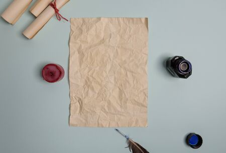 Raven feather, inkwell and old yellowed paper on red background. Copy space. Old letter.の写真素材