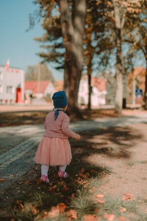 Adorable girl having fun on beautiful autumn day. authentic childhood imageの写真素材