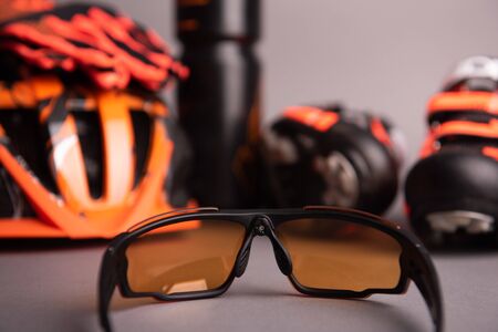 Helmet, gloves, shoes and water bottle - bicycle accessories. Orange color