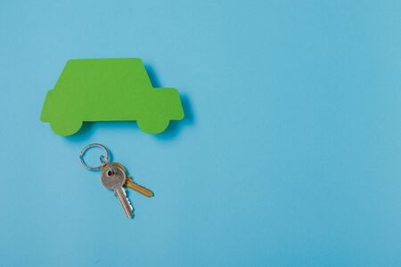 paper green cars figure with keys. top view on blue backgroundの写真素材