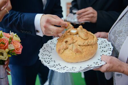 Traditional polish greeting the bride and groom by the parents with bread and salt. Vodka also in glasses.の写真素材
