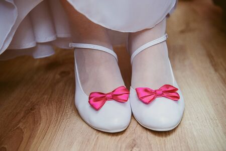 The bride shows white wedding shoes. Wedding detail. Close upの写真素材