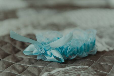 Bridesmaid helping slender bride lacing her wedding white dress, buttoning on delicate lace pattern...