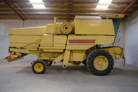 combine harvester standing ready for harvest in a warehouseの写真素材