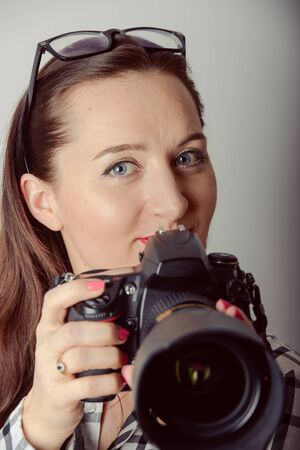 Woman-photographer takes images, isolated on gray backgroundの写真素材