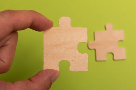 Man hand assembling puzzles on lime background.の写真素材