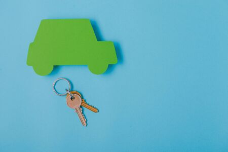 paper green cars figure with keys. top view on blue backgroundの写真素材