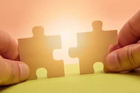 Man hand assembling puzzles on lime background.の写真素材