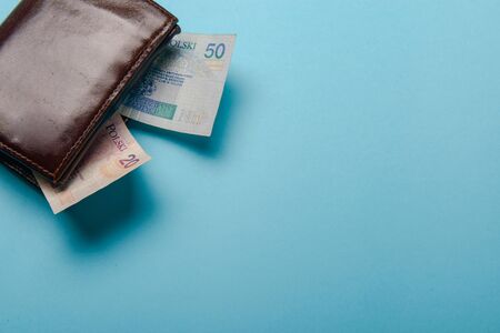brown mans leather wallet with money bills on a blue backgroundの写真素材