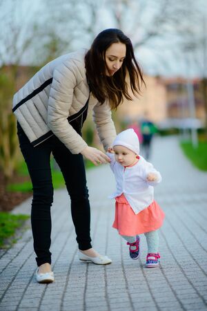 happy family mother and child little daughter running and playing on autumn walkの写真素材