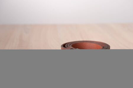 Leather belt on the wooden desk table