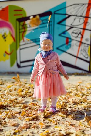 Adorable girl having fun on beautiful autumn day. Authentic picture.の写真素材