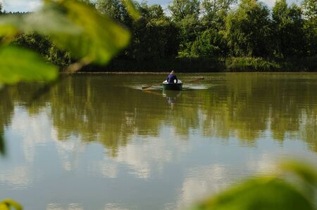 Bride and groom at a photo session in the nature. Newlyweds in the boat on the lake