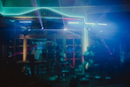 DJ plays music at wedding party. Colorful light rays.の写真素材