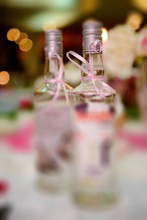 Bottle of cold vodka and wine bottle in bucket with ice and orange juice in jug on table, copy space. Alcohol bottles in ice bucket in restaurant. Wedding partyの写真素材