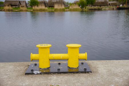 Two yellow mooring post at the harbor or marina port.