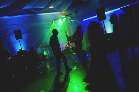 Bride and groom dancing the first dance at their wedding day. Guest on the dancefloor