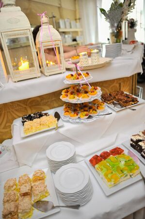 Delicious sweets on candy buffet. Wedding bakes on trays.の写真素材
