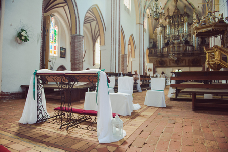 Church sanctuary before a wedding ceremony. Empty chairs for bride and groomのeditorial素材