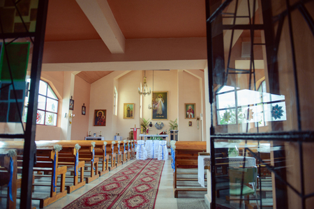 Church sanctuary before a wedding ceremony. Empty chairs for bride and groomのeditorial素材
