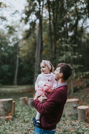 Little daughter riding father on shoulders.の写真素材
