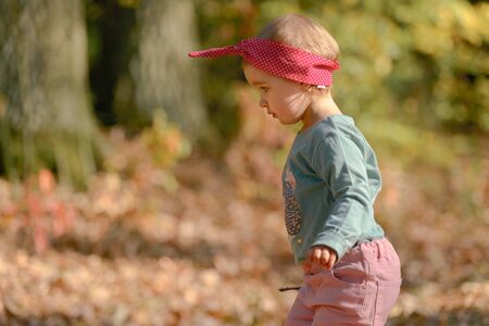 Adorable girl having fun on beautiful autumn day.の写真素材