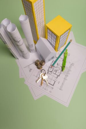 White family paper house, house projects plan and blueprints in the background. Minimalistic and...