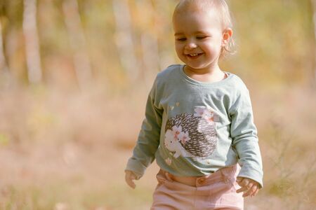Adorable girl having fun on beautiful autumn day.の写真素材