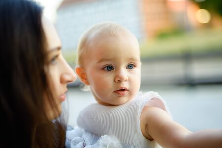 Happy mother and daughter in the park. Beauty nature scene with family outdoor lifestyle. Happy family resting together on the green grass, having fun outdoor. Happiness and harmony in family life.の写真素材