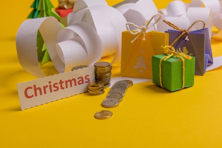 Holiday expenses concept. Long twisted christmas expenses list, presents, gifts, money coins and christmas textの写真素材