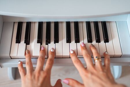 beautiful baby girl playing toy piano in light room.の写真素材