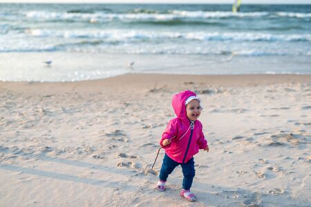 Adorable toddler girl on a sunny sand beach. Childhoodの写真素材