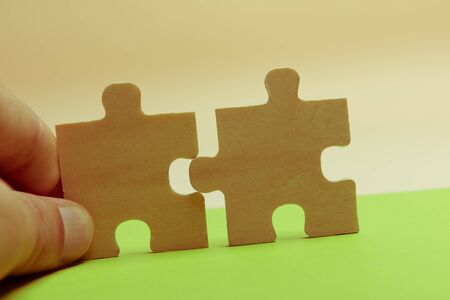 Man hand assembling puzzles on lime background.の写真素材