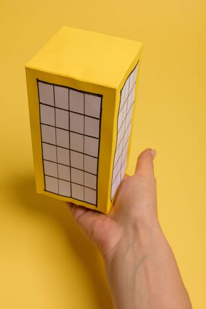 Yellow paper block of flats on yellow background paper. Minimalistic and simple concept, style. Copy space. Horizontal orientation.の写真素材