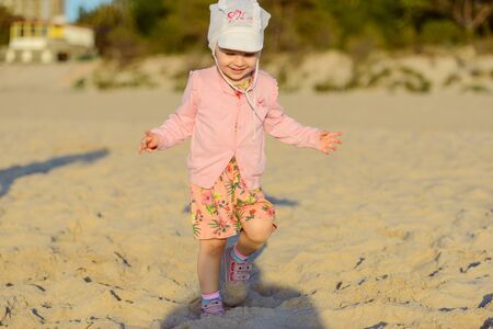 Adorable toddler girl on a sunny sand beach. Childhoodの写真素材