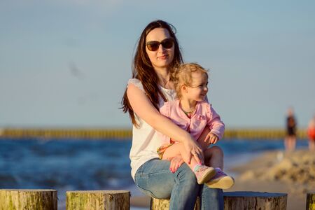 Mother and little daughter walking on the beach.の写真素材