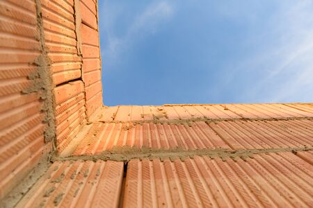 Interior of a Unfinished Red Brick House Walls under Construction without Roofing.の写真素材