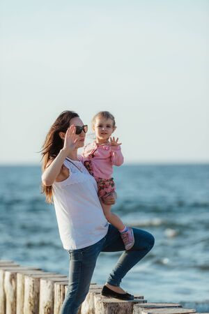 Mother and little daughter walking on the beach.の写真素材