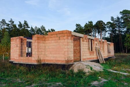 Exterior of a Unfinished Red Brick House Walls under Construction without Roofing.の写真素材