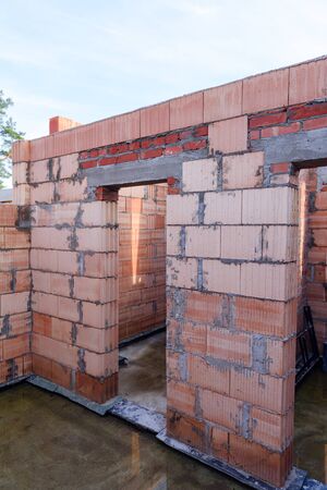 Interior of a Unfinished Red Brick House Walls under Construction without Roofing.の写真素材
