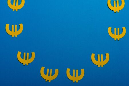Paper yellow symbols of euro currency on blue background. View from above with copy spaceの写真素材