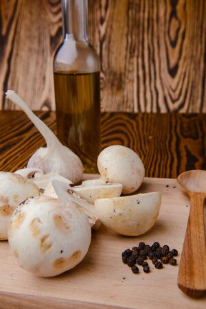 composition poured olive oil, mushrooms, garlic on wooden background. healthy foodの写真素材