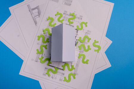 Paper skyscrapers , us dollar money, house projects plan and blueprints on blue background paper. Minimalistic and simple concept, style. Horizontal orientation. View from above. Copy space.の写真素材