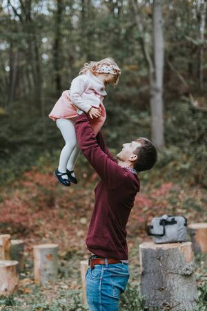 Little daughter riding father on shoulders.の写真素材