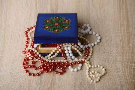 A photograph of gift box and red beads necklace on wooden backgroundの写真素材