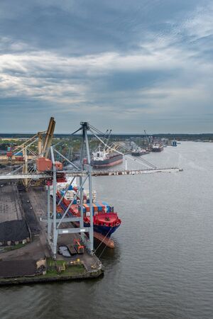 Container ship in export and import business and logistics. Shipping cargo to harbor by crane. Water transport International.の写真素材