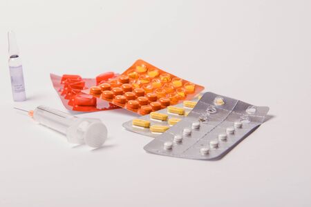 Multicolor tablets and pills capsules from glass bottle on blue background Heap of assorted various medicine tablets and pills. Health care Close-up Copy space.の写真素材
